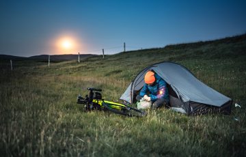 a man sitting on the tent near his bike