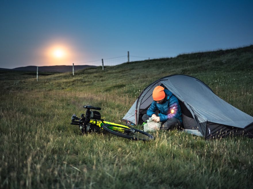 a man sitting on the tent near his bike