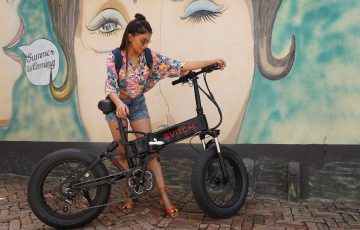 woman in printed shirt holding her bike