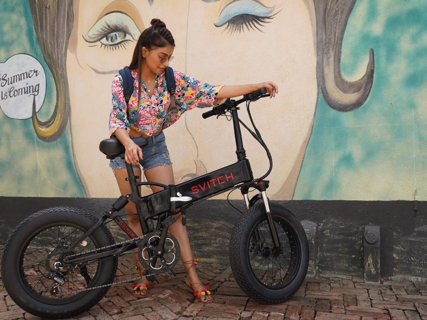 woman in printed shirt holding her bike