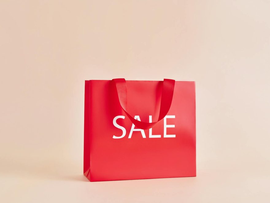 red paper bag with sale sign